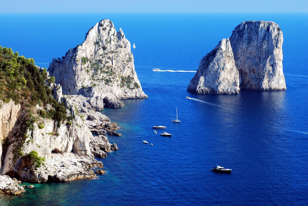 Faraglioni rocks close the Capri island in Italy with a beautiful blue sea color.